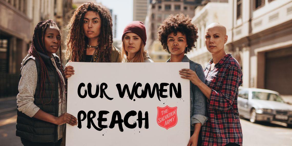 A group of women hold up a sign that says 'Our Women Preach' with Salvation Army Red Shield