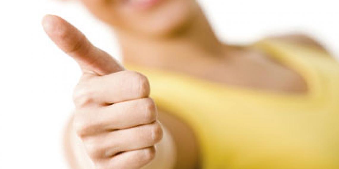 Woman smiling and giving a thumbs up