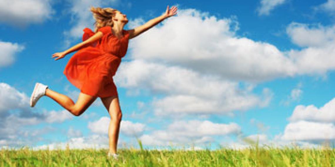 A woman happily running across a field
